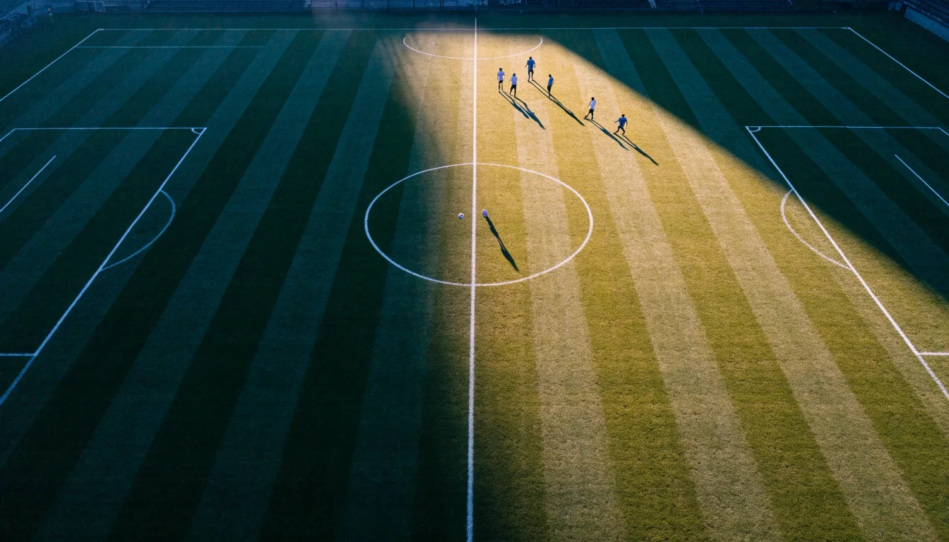 Ein Fussballplatz von oben gesehen, die Linien bilden ein helles Muster auf dem Rasen, Drohnenperspektive in der Morgendämmerung.