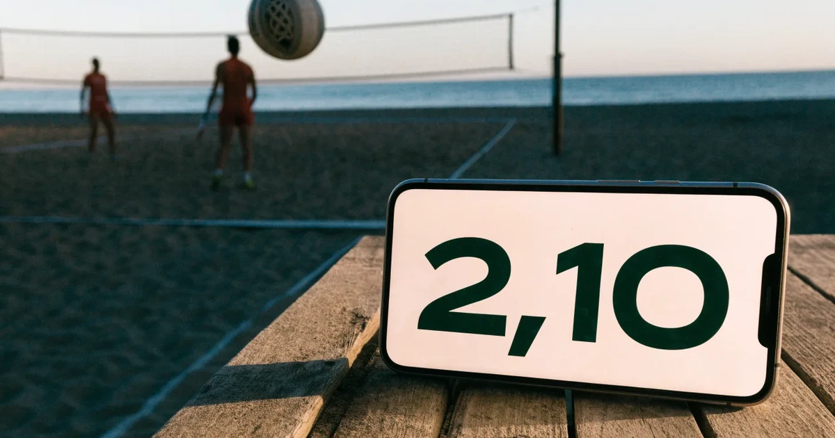Ein Volleyball liegt auf feinem hellem Sand, ein gespanntes Netz verschwimmt dahinter, das Licht kommt von einem weiten Meer.