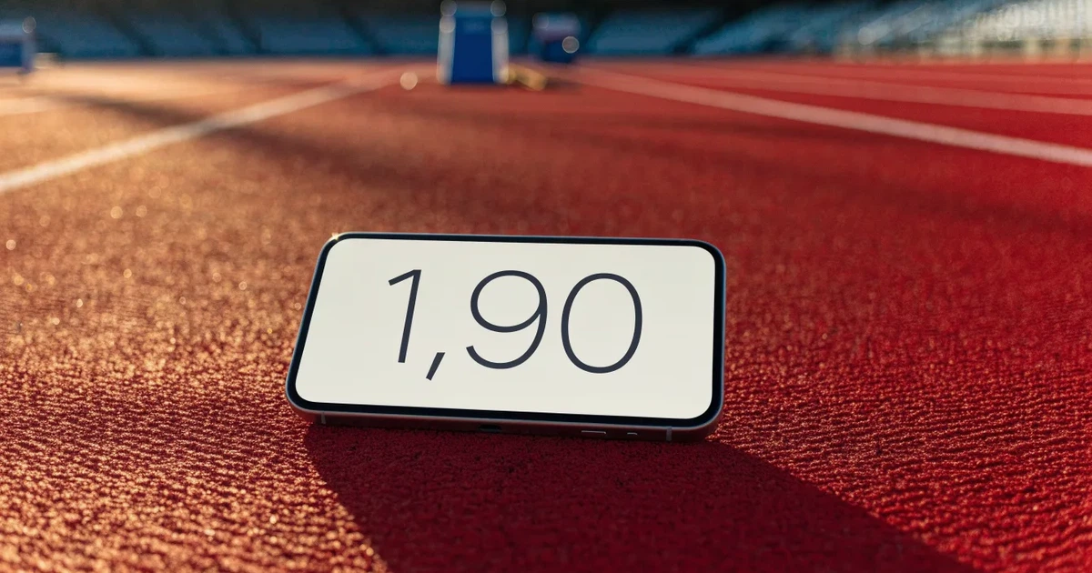 Eine rote Laufbahn mit weissen Linien leuchtet in der Morgensonne, im Hintergrund ein leeres Stadion.
